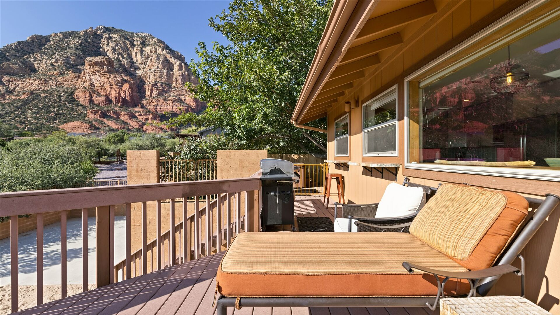 porch with sitting area and red rocks in background