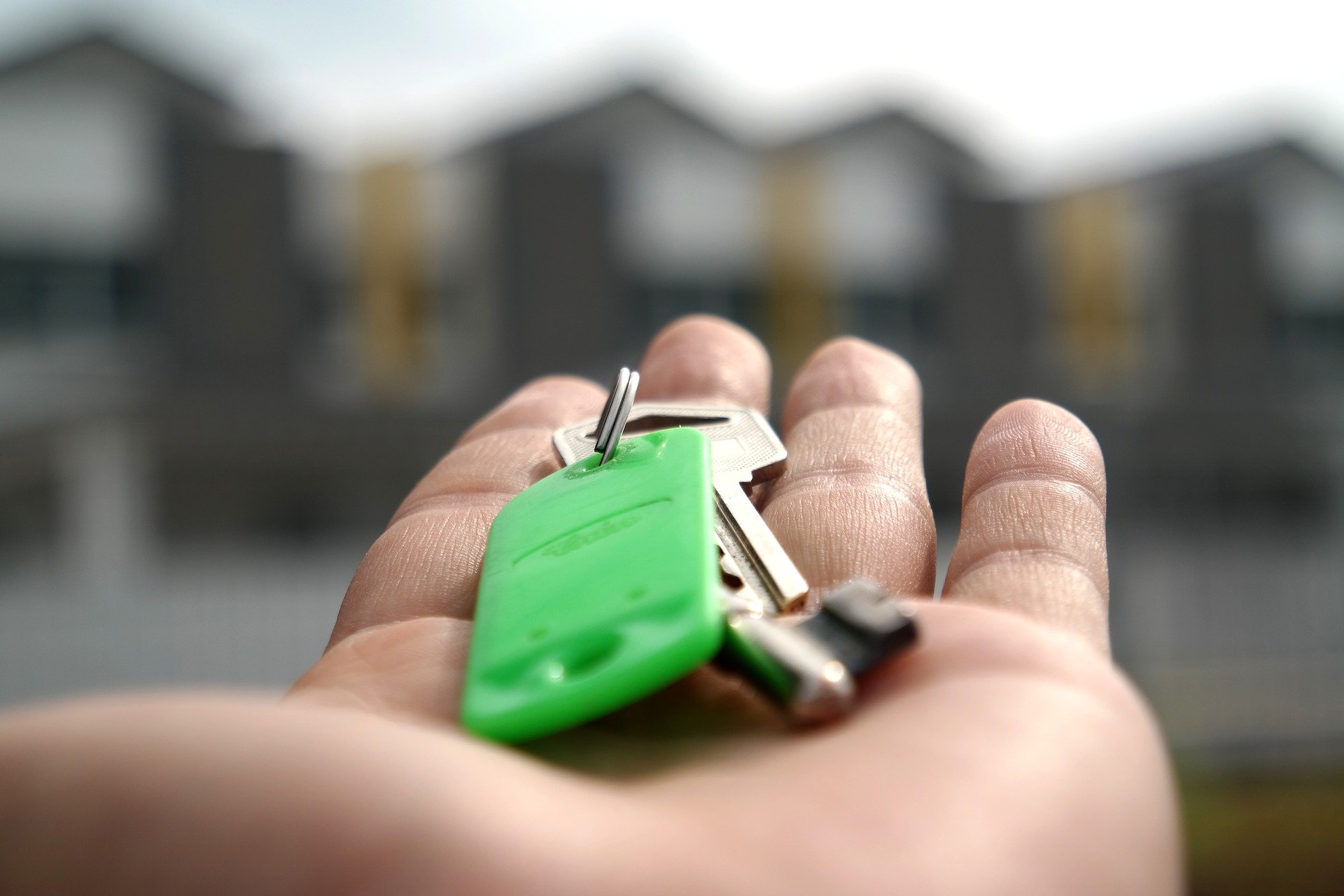person holding keys on green keychain